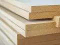 Stos płyt MDF, materiału drewnopochodnego, gotowego do użycia w meblarstwie i budownictwie.