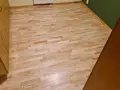 Jasny, odnowiony parkiet po cyklinowaniu lśni w słońcu. Drewniane meble dodają ciepła.