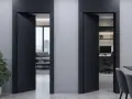 Dwa czarne, nowoczesne drzwi rewersyjne otwierają widok na salon i gabinet.