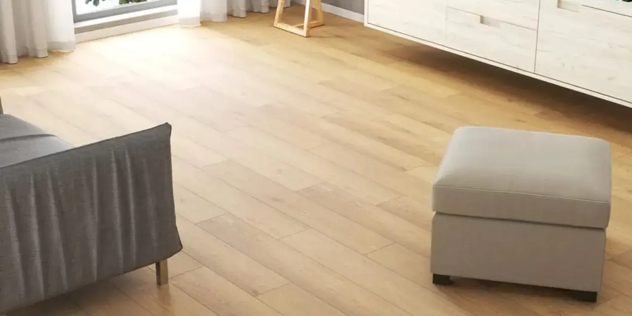 Jasne, oto propozycja:

Nowoczesny salon z jasnymi panelami winylowymi z twardym rdzeniem, szarą sofą i pufą.