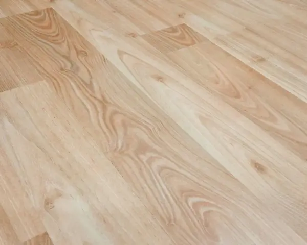 Jasne panele winylowe z widocznymi, naturalnymi rysami imitującymi drewno.
