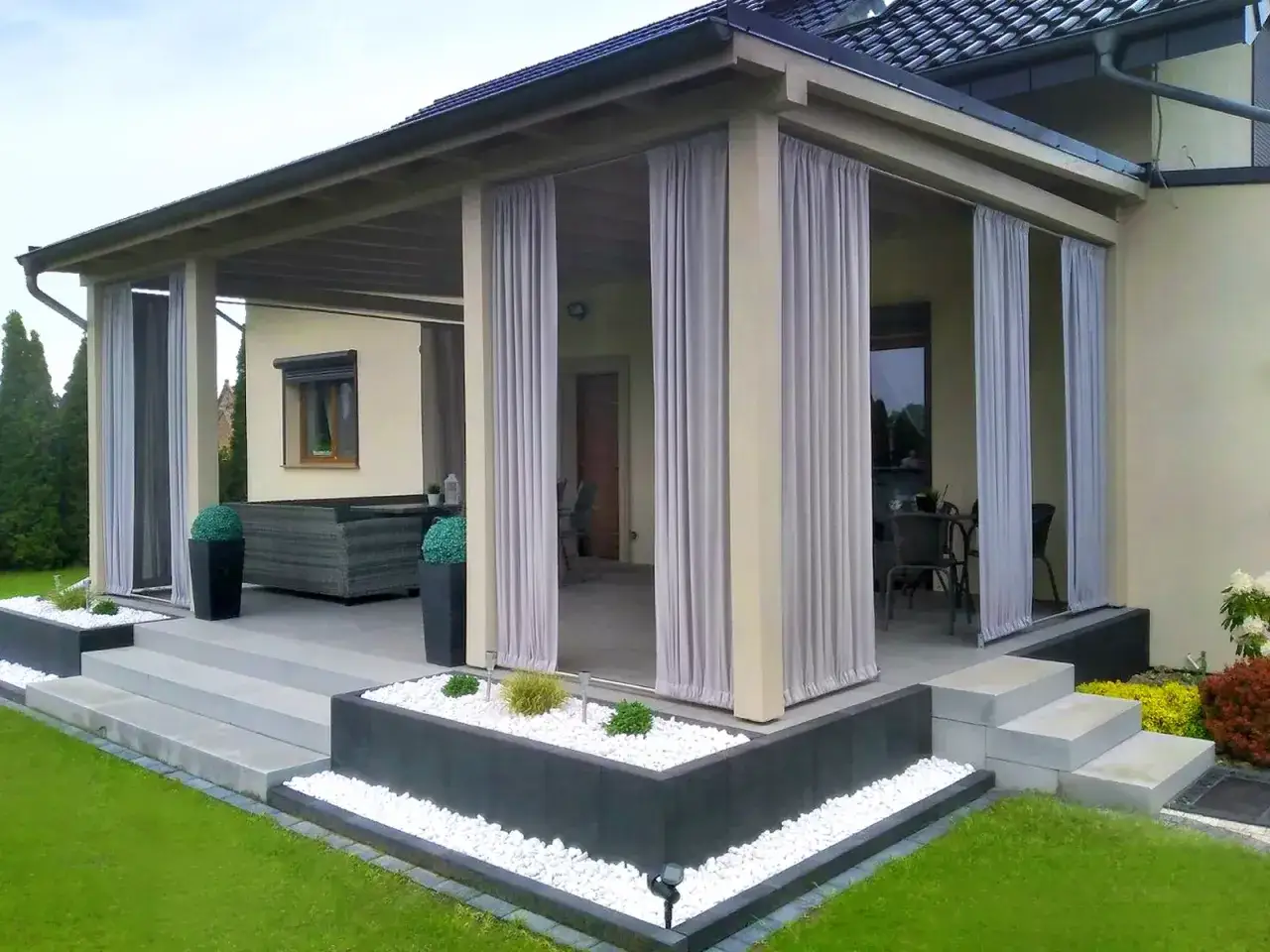 Zasłony tarasowe tworzą przytulną przestrzeń. Eleganckie rozwiązanie, czym osłonić taras.