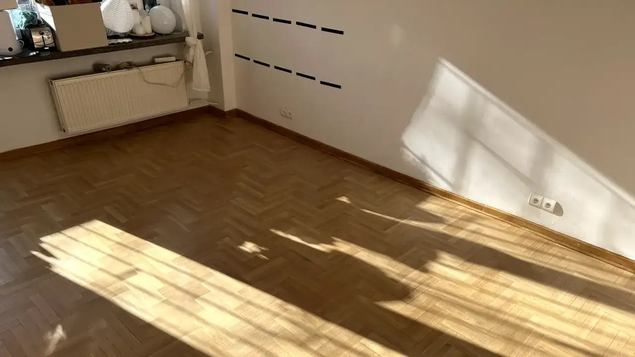 Słoneczne promienie padają na parkiet. Zastanawiasz się, czym myć podłogę drewnianą lakierowaną, by zachować jej blask?